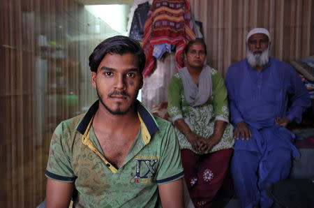 Mohammad Rafiq, 18, poses with his parents inside their house in Ahmedabad, April 17, 2019. REUTERS/Amit Dave