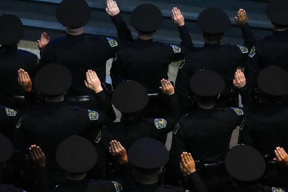 New Austin police officers hold up their right hands to take their oath of service at their graduation ceremony last month. The Austin City Council in 2020 voted unanimously to prohibit the Police Department from using facial recognition technology.