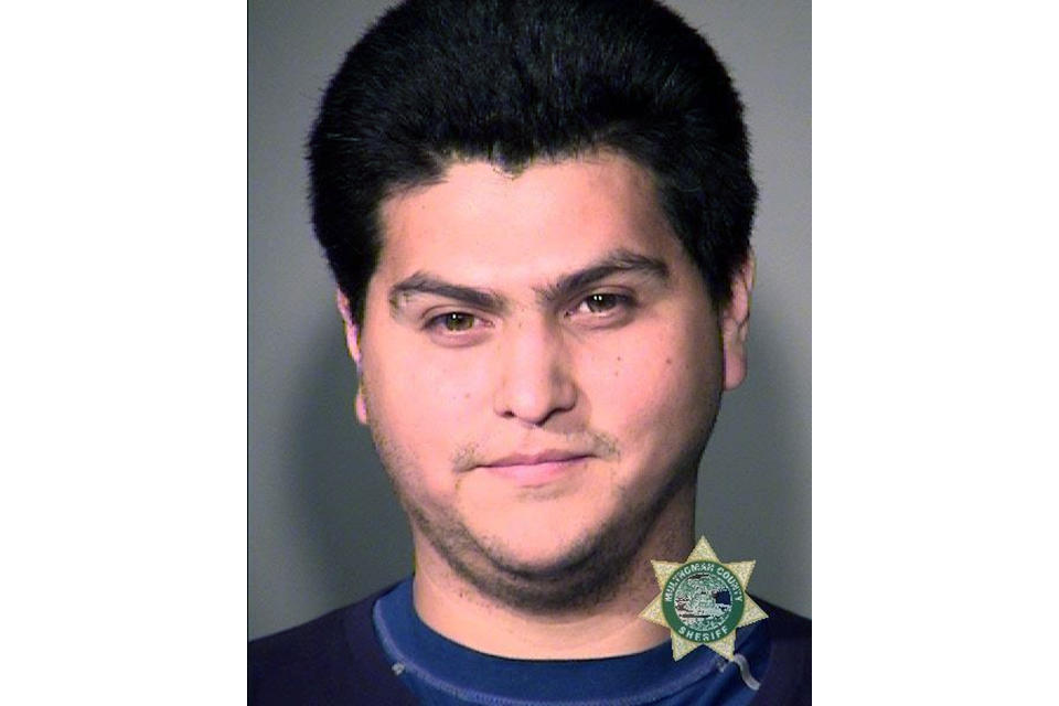 In this undated Multnomah County Sheriff photo is Antonio Scott Zamora. The Portland Police Bureau on Tuesday, Aug. 27, 2019, arrested another person in the aftermath of a protest and counter-protest that led to clashes between right-wing and left-wing demonstrators. Court documents say Antonio Scott Zamora was in a crowd of masked anti-fascist demonstrators who surrounded a bus carrying the far-right groups Proud Boys and Patriot Prayer. Authorities say Zamora, who was later identified by his teal-colored shirt and rainbow-colored face mask, hit the bus and threw an object at its window. Several videos of the attack on the bus, which was stopped in heavy traffic, went viral in the days after the Aug. 17 protest. (Portland Police Bureau via AP)