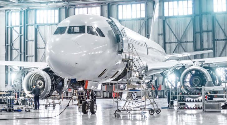 a private plane inside a hangar is prepared for a flight. represent aerospace stocks. Safe Dividend Stocks