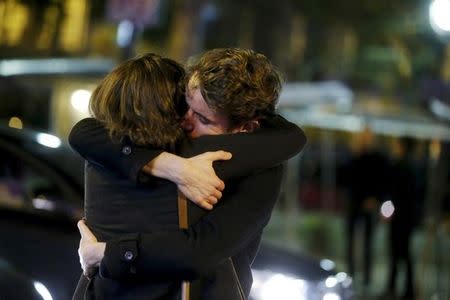 People hug on the street near the Bataclan concert hall following fatal attacks in Paris, France, November 14, 2015. REUTERS/Christian Hartmann
