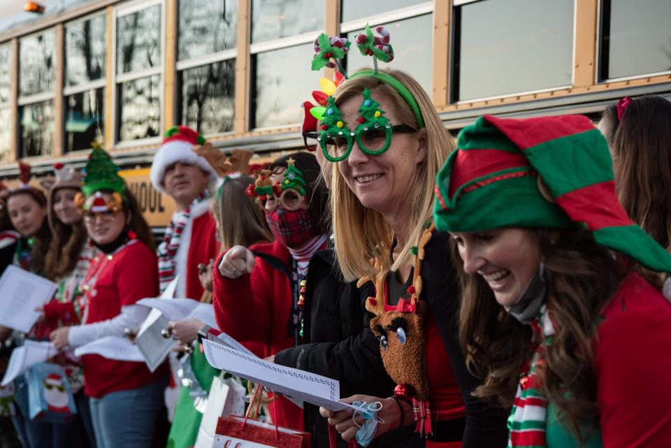 File- Kutz Elementary School teachers and staff sing to their students on the first stop of the "Holly Jolly Express," in Doylestown Township on Tuesday, December 14, 2021, in an effort to spread holiday cheer through music and treats, while collecting donations for A Women's Place.