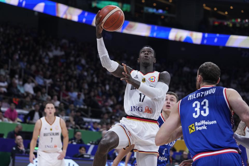 El escolta alemán Dennis Schroder (17) dispara al aro ante el centro Nikola Milutinov (33) durante la final del Mundial de baloncesto, el domingo 10 de septiembre de 2023, en Manila. (AP Foto/Michael Conroy)