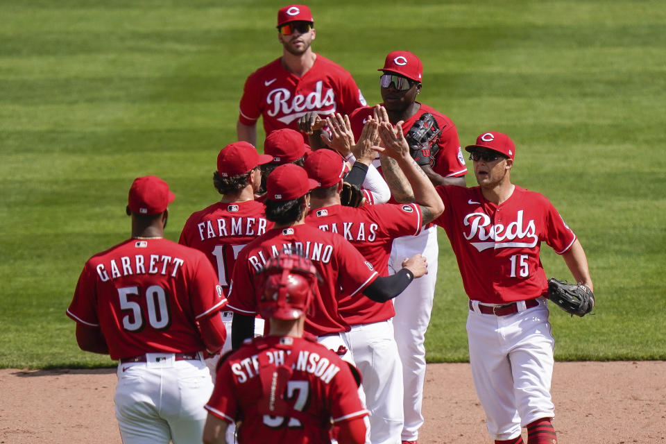 Cincinnati Reds' teammates celebrate after defeating the Pittsburgh Pirates 11-4 at Great American Ball Park in Cincinnati, Wednesday, April 7, 2021. (AP Photo/Bryan Woolston)