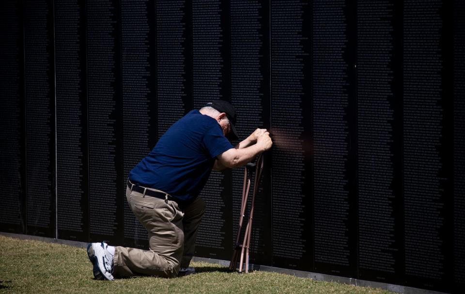 Robert Griffith, an Army veteran pays his respects to a friend and Marine who was killed in the Vietnam war. He and his wife were visiting the Vietnam Traveling Wall and Cost of Freedom display at Lakes Regional Park in Fort Myers on Thursday, April 25, 2024.