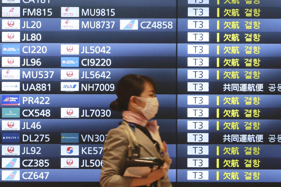 A woman wearing a face mask to protect against the spread of the coronavirus walks in the Haneda International Airport in Tokyo, Tuesday, Sept. 1, 2020. Major Asian share indexes edged lower Tuesday in mostly muted trading after a retreat overnight on Wall Street. (AP Photo/Koji Sasahara)