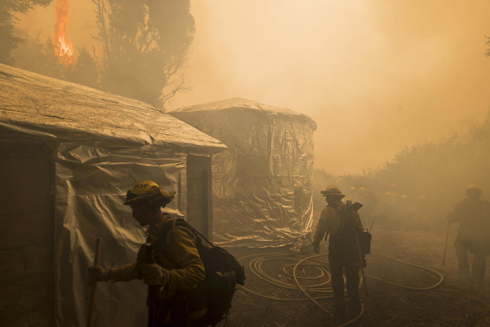 Firefighters from Vandenberg Air Force Base monitor a controlled burn to help slow the Dolan Fire at Limekiln State Park in Big Sur, Calif,. Friday, Sept. 11, 2020. (AP Photo/Nic Coury)