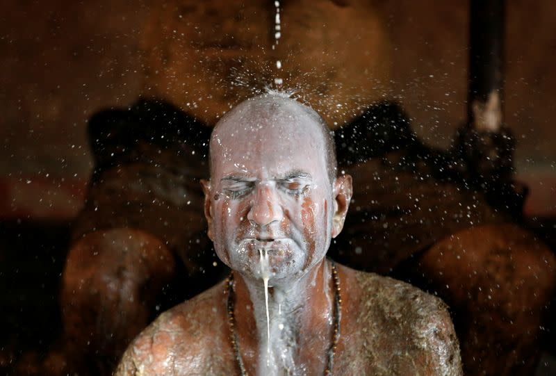 Ashok Oza bathes in cow milk to remove cow dung from his body during "cow dung therapy" on outskirts of Ahmedabad