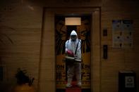 A volunteer from the Blue Sky Rescue team wearing a protective suit is seen at the Qintai Grand Theatre in Wuhan