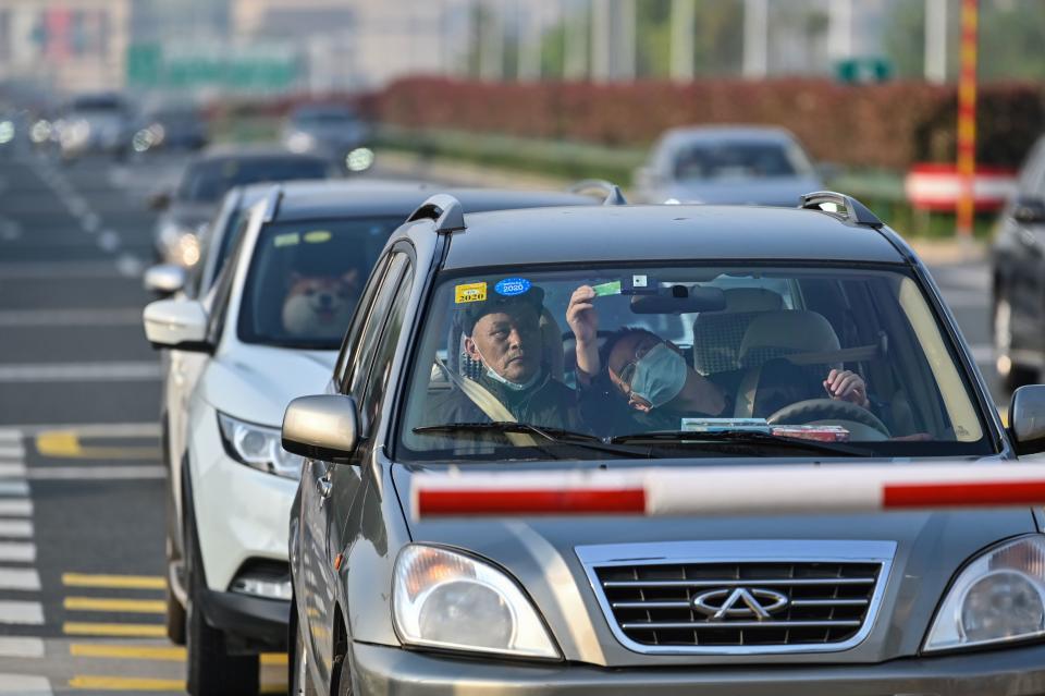 Motorists cross a toll booth after an outbound travel ban was lifted in Wuhan.