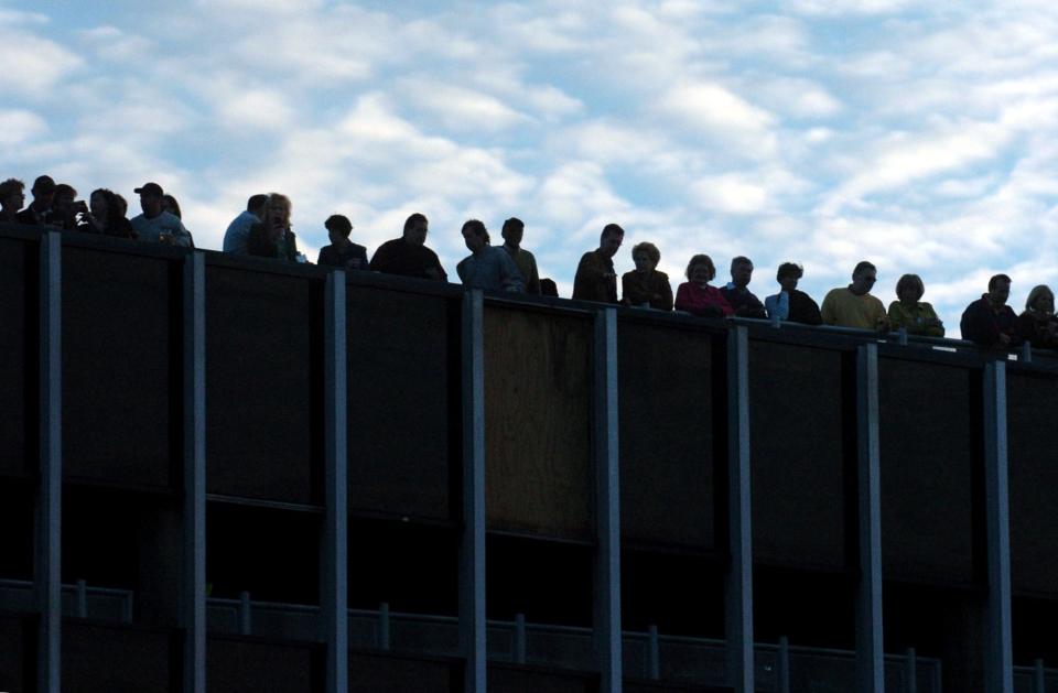 VIPs including goverment officials, sponsors, and committee members line the parking garage on Green and Old Streets Saturday evening to watch Hootie & the Blowfish perform during the Dogwood Festival.