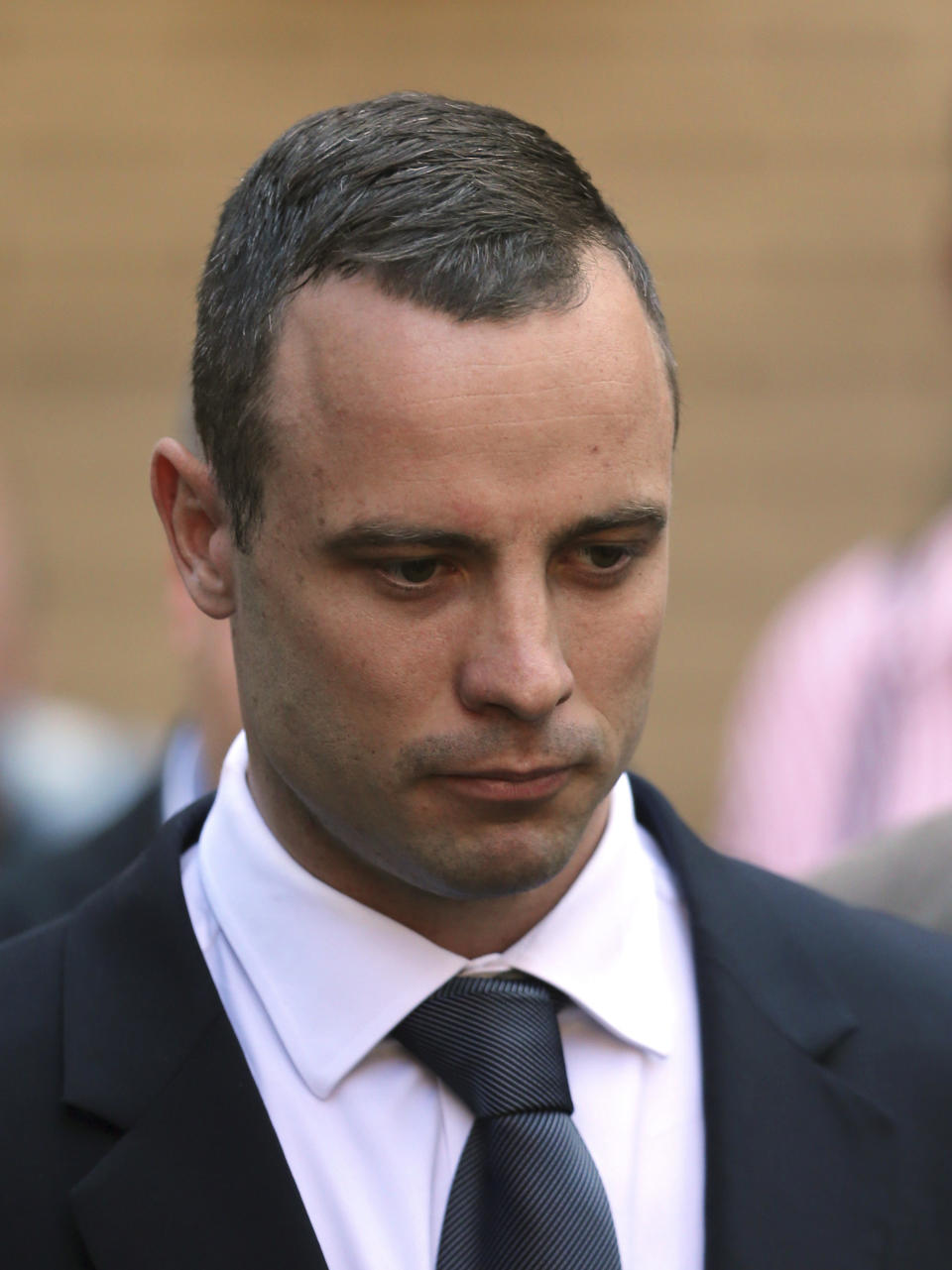 Oscar Pistorius leaves the high court in Pretoria, South Africa, Wednesday, May 14, 2014. The judge overseeing the murder trial of Pistorius on Wednesday ordered the double-amputee athlete to undergo psychiatric tests, meaning that the trial proceedings will be delayed. (AP Photo/Themba Hadebe)