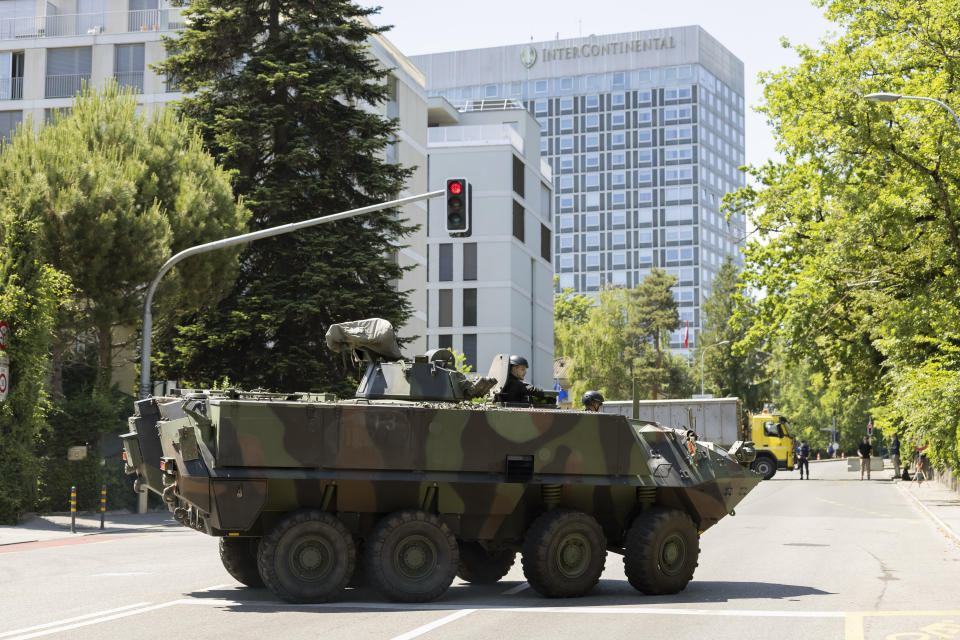 An armored vehicle and a truck block roadway access to the Inter Continental hotel before the arrival of United States President Joe Biden, Tuesday, June 15, 2021, in Geneva, Switzerland. The meeting between US President Joe Biden and Russian President Vladimir Putin is scheduled in Geneva for Wednesday, June 16. (Cyril Zingaro/Keystone via AP)