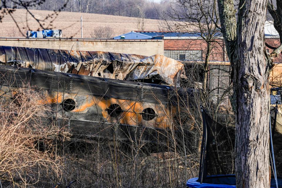 A derailed train car is seen from the backyard of home in East Palestine, Ohio. About 50 train cars, 10 of which carried hazardous materials, derailed in a fiery wreck on Feb. 3. Vinyl chloride, a gas contained in five of the cars, was released and burned to prevent explosion, causing toxic fumes to be released in the area.