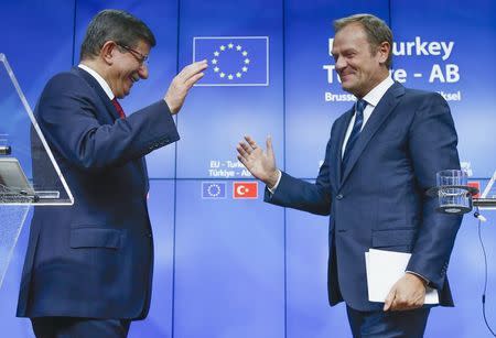 Turkish Prime Minister Ahmet Davutoglu (L) and European Council President Donald Tusk greet each other after a news conference following a EU-Turkey summit in Brussels, Belgium November 29, 2015. REUTERS/Yves Herman