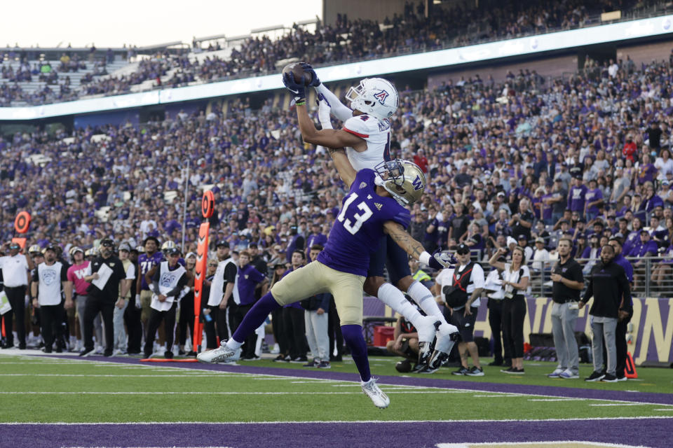 FILE - Arizona wide receiver Tetairoa McMillan catches a pass for a touchdown over Washington linebacker Kamren Fabiculanan during the second half of an NCAA football game, Saturday, Oct. 15, 2022, in Seattle. McMillan, the highest-rated recruit in school history, had a strong first season, leading all FBS true freshmen with 702 yards receiving on 39 receptions and eight touchdowns. (AP Photo/John Froschauer, File)