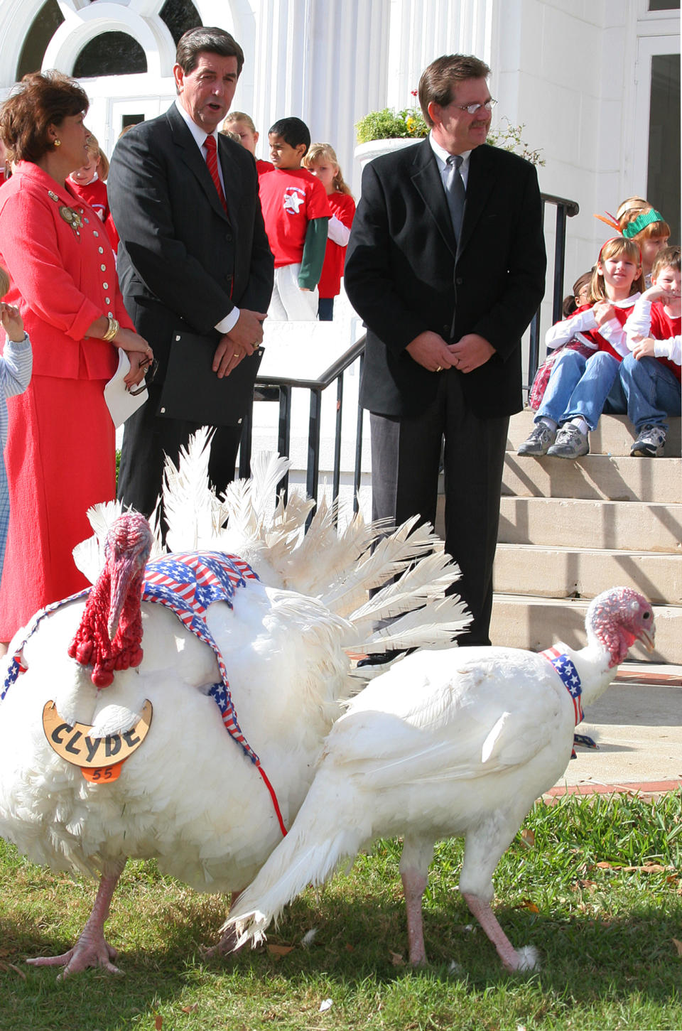 Turkey Clyde 55, left, awaits an official pardon from Alabama Gov. Bob Riley Tuesday morning, Nov. 16, 2004 with escort “Henrietta” on the front lawn of the Governor’s Mansion in Montgomery, Ala. The first lady Patsy Riley and Alabama Agriculture Commissioner Ron Sparks, right, stand alongside the Governor in front of elementary students from several Alabama schools. Pardoning a turkey from Thanksgiving dinner started in 1949 by Alabama Gov. James “Big Jim” Folsom.