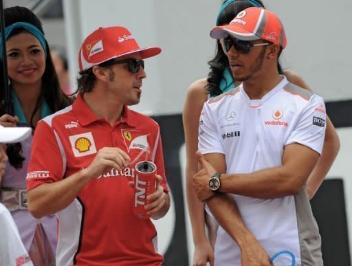 Ferrari's Fernando Alonso chats to McLaren rival Lewis Hamilton, who starts the Malaysian Grand Prix in pole