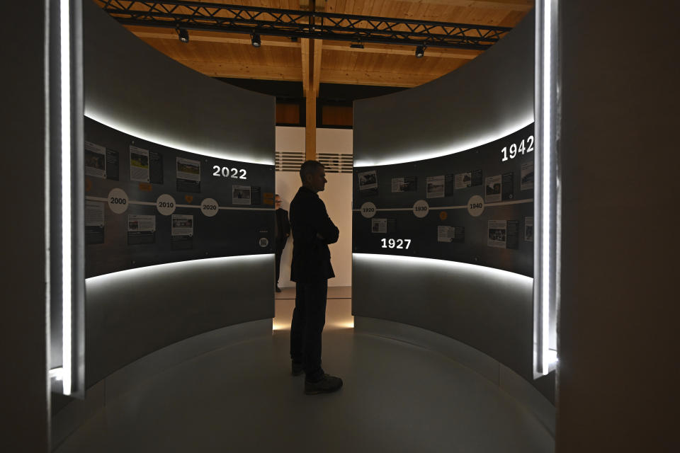 A journalist looks at the exhibition of the Holocaust Memorial of Roma and Sinti before the opening ceremony, in Lety, Czech Republic, Tuesday, April 23, 2024. (Lubos Pavlicek/CTK via AP)