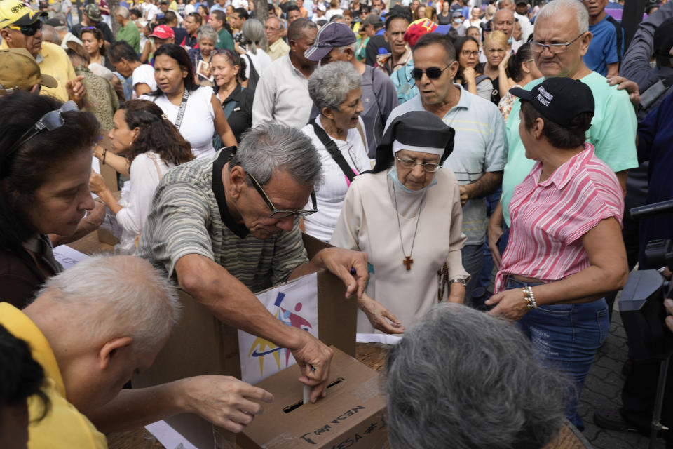 A voter casts his ballot at a polling station during opposition primary presidential election at Luis Brion square in Caracas, Venezuela, Sunday, Oct. 22, 2023. The opposition will pick one candidate to challenge President Nicolás Maduro in 2024 presidential elections. (AP Photo/Matias Delacroix)