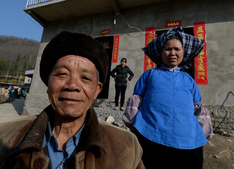 Rural residents pose in front of their new houses near the city of Anshun, Guizhou Province on February 20, 2014