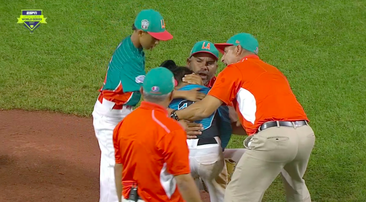 Members of Venezuela comforted Dominican Republic pitcher Edward Uceta after he gave up a walk-off hit. (Screen shot via Deadspin)