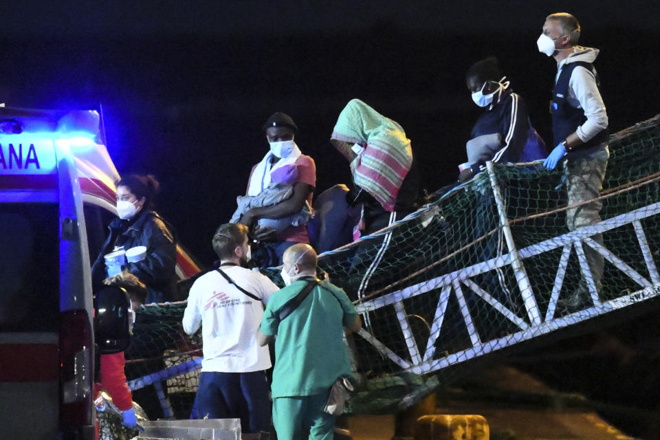 Migrants disembark from the Norway-flagged Geo Barents rescue ship carrying 572 migrants, in Catania's port, Sicily, southern Italy, Sunday, Nov. 6, 2022. The Geo Barents, and the German-flagged Humanity1 have been allowed to disembark what the Italian authorities defined "vulnerable people" and minors, while other two ships carrying rescued migrants remained at sea. (AP Photo/Salvatore Cavalli)