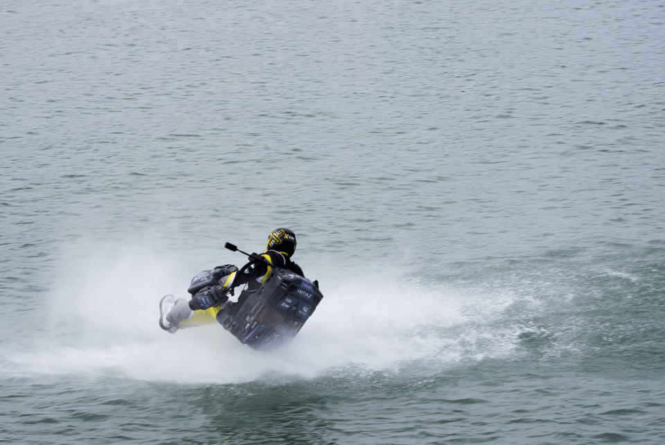 Emirati jet suit pilot Ahmed al-Shehhi crashes into the water during a race in Dubai, United Arab Emirates, Wednesday, Feb. 28, 2024. Dubai on Wednesday hosted what it called its first-ever jet suit race. Racers zipped along a route with the skyscrapers of Dubai Marina looming behind them, controlling the jet engines on their hands and their backs. (AP Photo/Jon Gambrell)