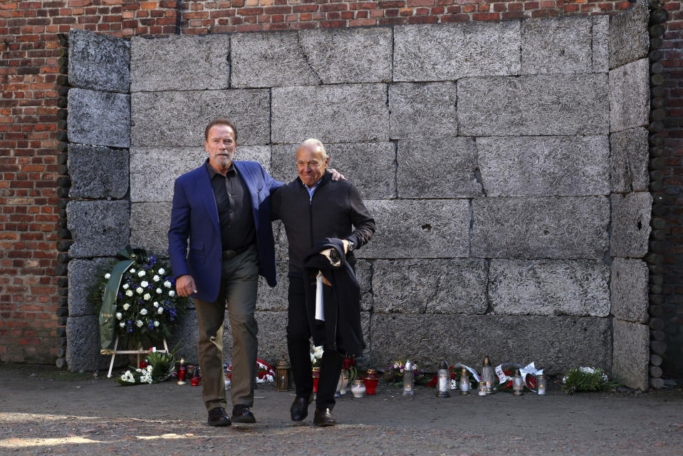 Arnold Schwarzenegger, izquierda, y Simon Bergson, presidente de Auschwitz Jewish Center Foundation, caminan junto a un paredón en el antiguo campo de exterminio nazi Auschwitz - Birkenau en Oswiecim, Polonia, el miércoles 28 de septiembre de 2022. Schwarzenegger visitó el sitio del antiguo campo de exterminio nazi en Auschwitz y se reunió con sobrevivientes del Holocausto e hijos de sobrevivientes para enviar un mensaje contra el prejuicio y la intolerancia. (Foto AP/Michal Dyjuk)