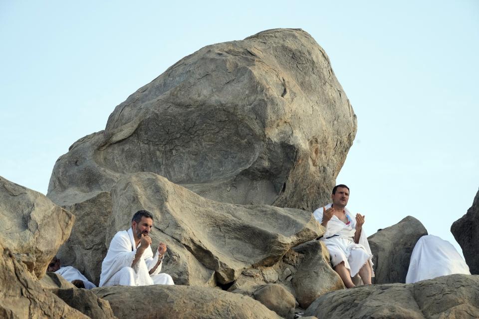 Muslim pilgrims pray on top of the rocky hill known as the Mountain of Mercy, on the Plain of Arafat, during the annual hajj pilgrimage, near the holy city of Mecca, Saudi Arabia, Friday, July 8, 2022. (AP Photo/Amr Nabil)