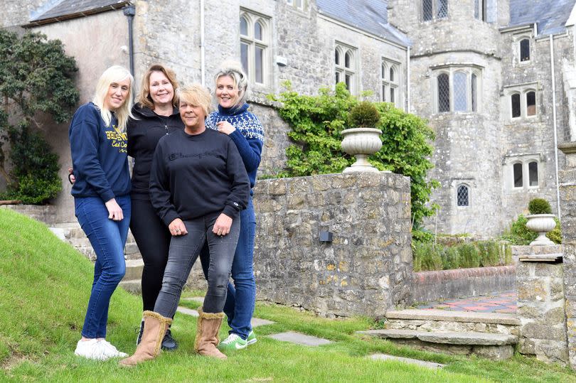 Four women stand in front of the house