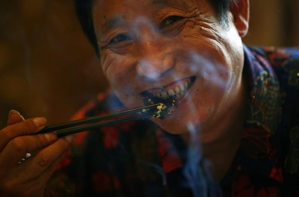 Yang Hongchang, boss of a snake rearing company eats a snake at a restaurant in Zisiqiao village, Zhejiang Province June 15, 2011. REUTERS/Aly Song