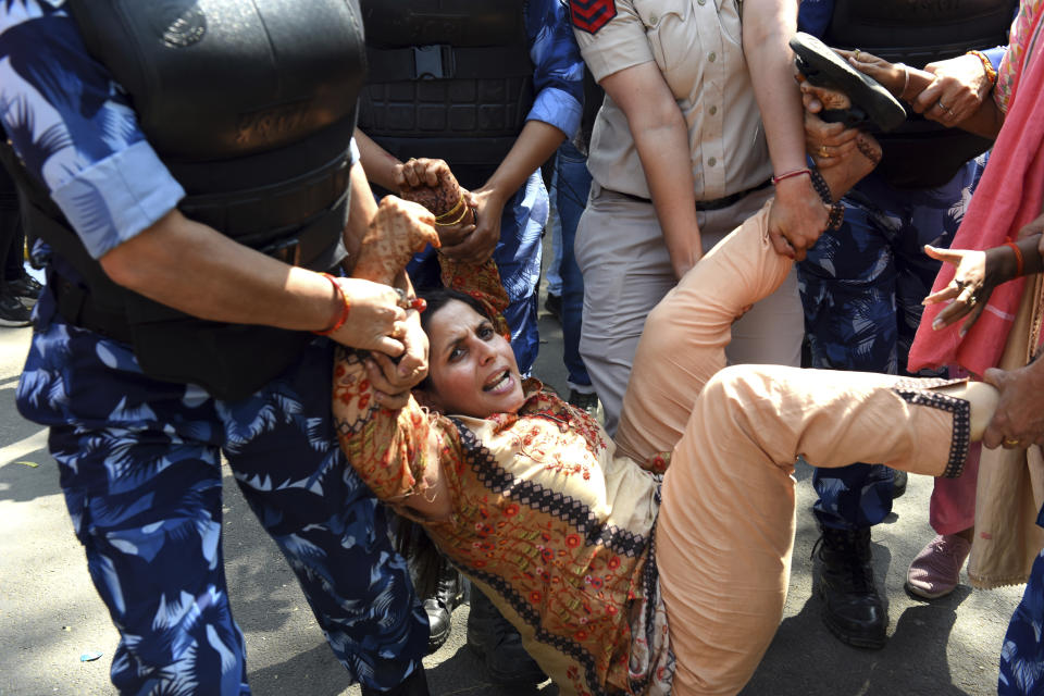 A supporter of opposition Congress party is detained by police while protesting against their leader Rahul Gandhi's expulsion from Parliament in New Delhi, India, Monday, March 27, 2023. Gandhi was expelled from Parliament a day after a court convicted him of defamation and sentenced him to two years in prison for mocking the surname Modi in an election speech. (AP Photo/Deepanshu Aggarwal)