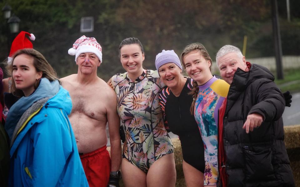 Swimmers prepare to brave the sea in Freshwater Bay, Totland, Isle of Wight