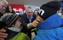 Liberal leader Philippe Couillard (C) squeezes a child's cheek during a campaign stop in Roberval, April 6, 2014. Quebec voters will head to the polls in a provincial election on April 7. REUTERS/Mathieu Belanger (CANADA - Tags: POLITICS ELECTIONS)