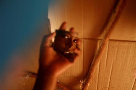 Zeinab, 14, looks in a small mirror as she brushes her teeth using a chewing stick inside her shelter at a camp for internally displaced people from drought hit areas in Dollow, Somalia April 3, 2017. REUTERS/ Zohra Bensemra