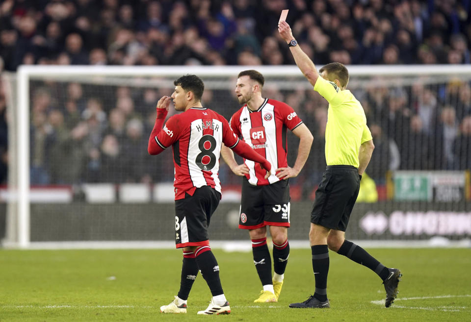 Referee Michael Salisbury, right, shows a red card to Sheffield United's Rhian Brewster, not in photo, for serious foul play following a on-pitchside VAR check during the English Premier League soccer match between Sheffield United and West Ham United at Bramall Lane, in Sheffield, England, Sunday, Jan. 21, 2024. (Mike Egerton/PA via AP)