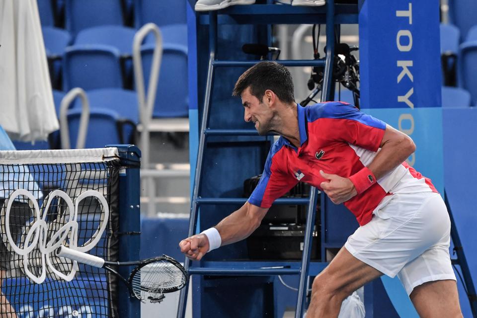 Djokovic smashes a racket after throwing one into the stands (AFP via Getty Images)