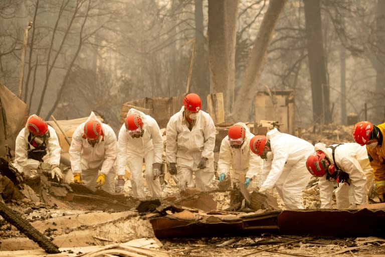 Rescue workers sift through rubble in search of human remains at a burned property in Paradise, California