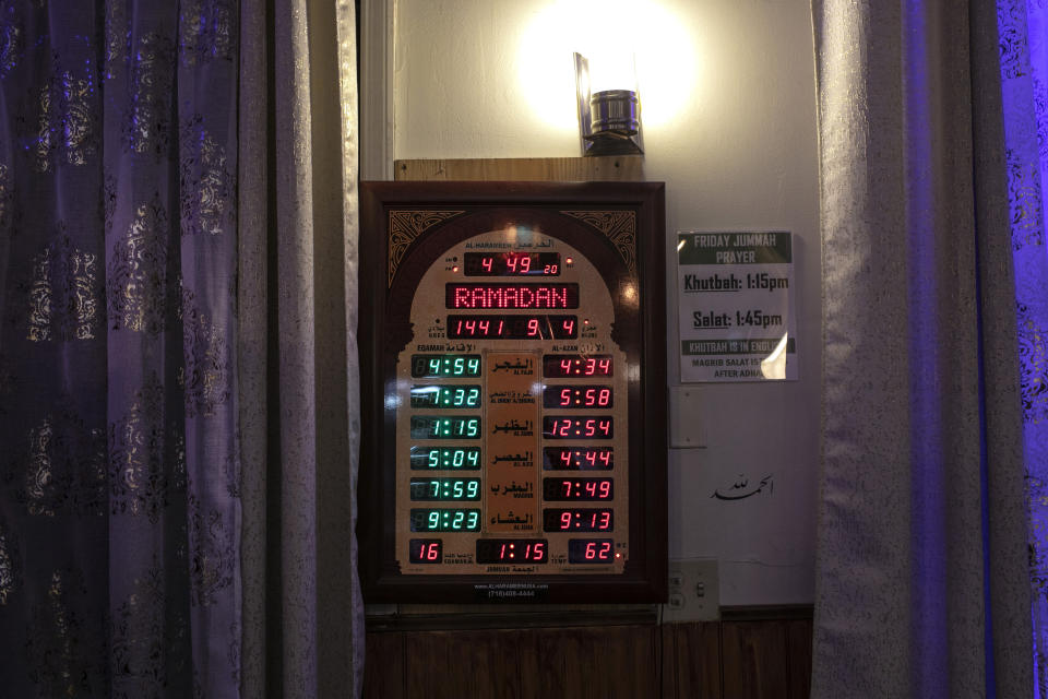 A clock displaying Muslim prayer times during the month of Ramadan hangs on a wall of the mosque at the Muslim Community Center in the Bay Ridge neighborhood of Brooklyn in New York, on Monday, April 27, 2020. (AP Photo/Wong Maye-E)