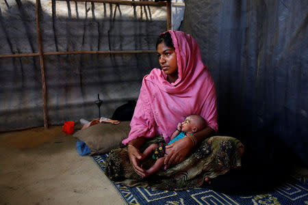 Asmot Ara, 18, holds her seven-day-old unnamed daughter as she poses for a photograph inside their shelter in Balukhali unregistered refugee camp in Cox’s Bazar, Bangladesh, February 8, 2017. REUTERS/Mohammad Ponir Hossain