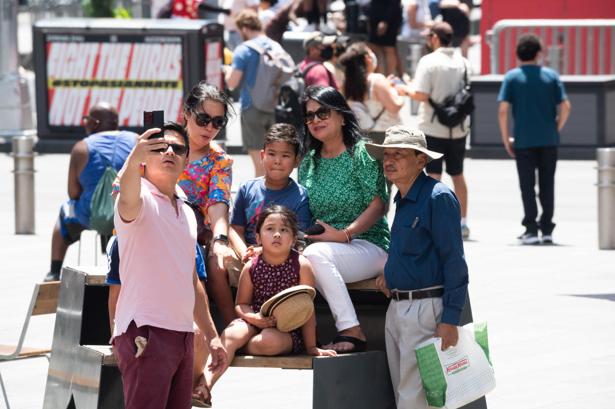 People take a selfie in Times Square on May 23, 2021 in New York City. On May 19, all pandemic restrictions, including mask mandates, social distancing guidelines, venue capacities and restaurant curfews were lifted by New York Governor Andrew Cuomo. (Noam Galai/Getty Images)