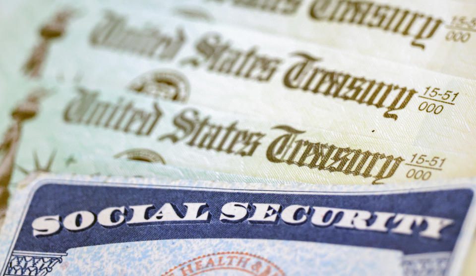 In this photo illustration, a Social Security card sits alongside checks from the U.S. Treasury.