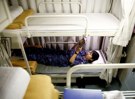 A female sailor on Japanese helicopter carrier Kaga reads a book on her bed during a break after lunch in the Indian Ocean, September 28, 2018. Japan has one of the world's largest navies, with 45,000 crew on more than 100 vessels, including about 20 submarines, more than 40 destroyers and four helicopter carriers, such as the Kaga. REUTERS/Kim Kyung-Hoon