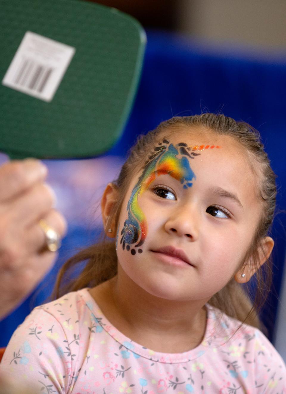 Five-year-old JaeLynn Williams looks at her unicorn face paint during the Lubbock Arts Festival, Saturday, April 9, 2022, at Lubbock Memorial Civic Center. Williams got a unicorn because "they're my favorite."