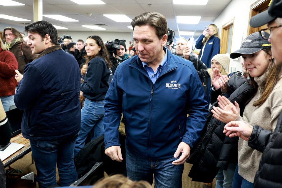 A man with a blue sweatshirt moves through a crowd of people gathered in his honor.