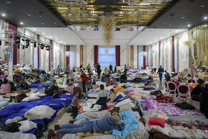 FILE - Refugees who fled the Russian invasion from neighboring Ukraine sit inside a ballroom converted into a makeshift refugee shelter at a hotel in Suceava, Romania, Friday, March 4, 2022. Since Russia launched its attacks against Ukraine on Feb. 24, more than 6 million people have fled war-torn Ukraine, the United Nations refugee agency announced Thursday, May 12, 2022. (AP Photo/Andreea Alexandru, File)