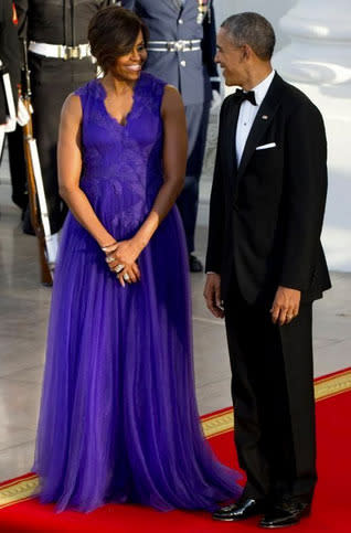 Michelle Obama with her husband, President Barack Obama, in an electric purple Tadashi Shoji gown.