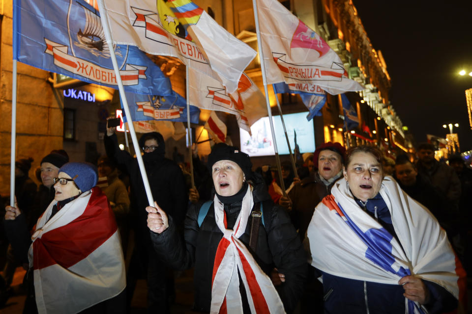 Demonstrators covered by old Belarusian flags gather to protest closer integration with Russia, which protesters fear could erode the post-Soviet independence of Belarus, in downtown in Minsk, Belarus, Friday, Dec. 20, 2019. The presidents of Belarus and Russia have met to discuss deeper economic ties between the two close allies amid mounting concerns in Minsk that Moscow ultimately wants to subdue its neighbor. (AP Photo/Sergei Grits)