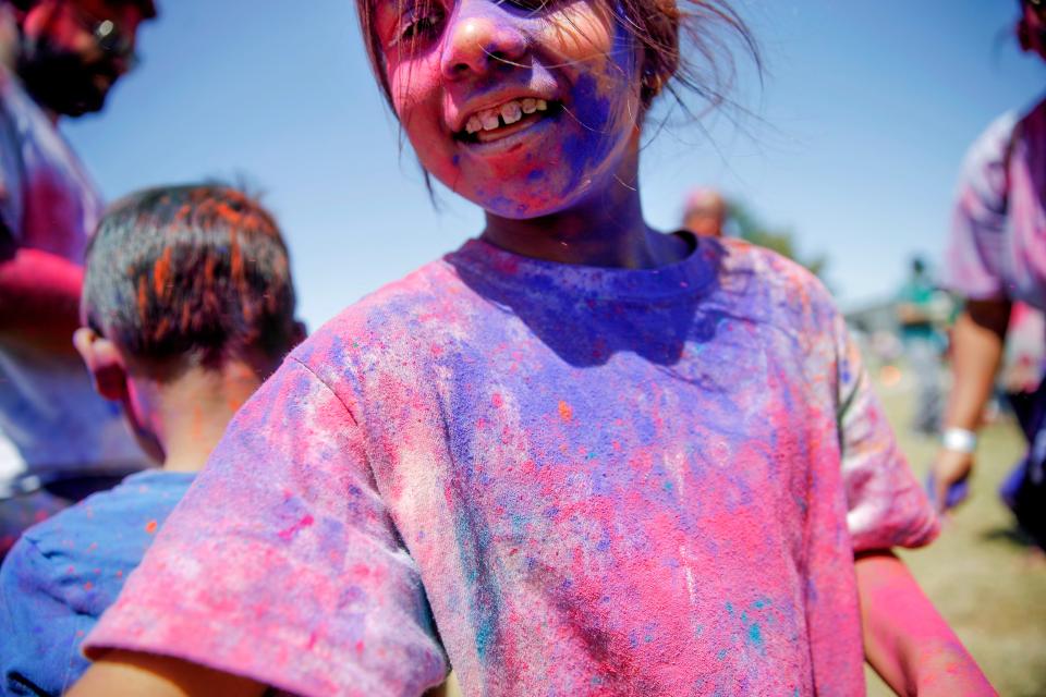 Ojasvi Mayank, 7, plays with colored powder during the Indian Association of Oklahoma's Holi Festival in Logan County, Okla., Saturday, April 9, 2022. 